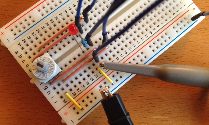 breadboard with LED, binary code switch and oscilloscope probes